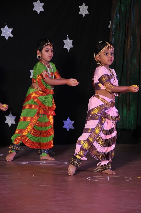Two young students in traditional costume performing a dance